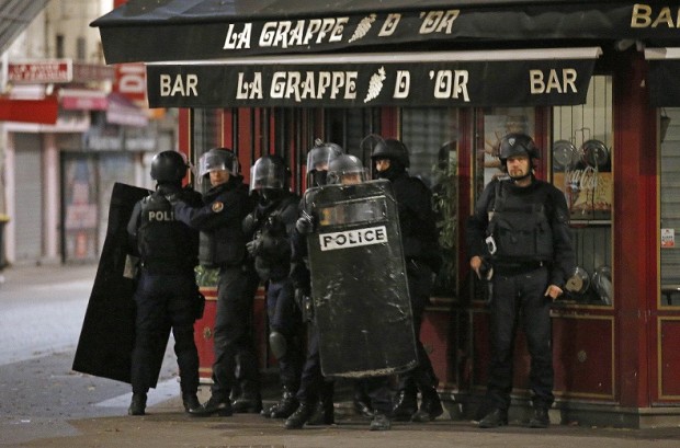Police officers take up positions in Saint Denis, a northern suburb of Paris, Wednesday, Nov. 18, 2015. Authorities in the Paris suburb of Saint Denis are telling residents to stay inside during a large police operation near France's national stadium that two officials say is linked to last week's deadly attacks. (AP Photo/Francois Mori)