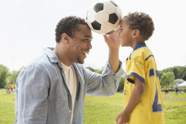 Father and son playing with soccer ball