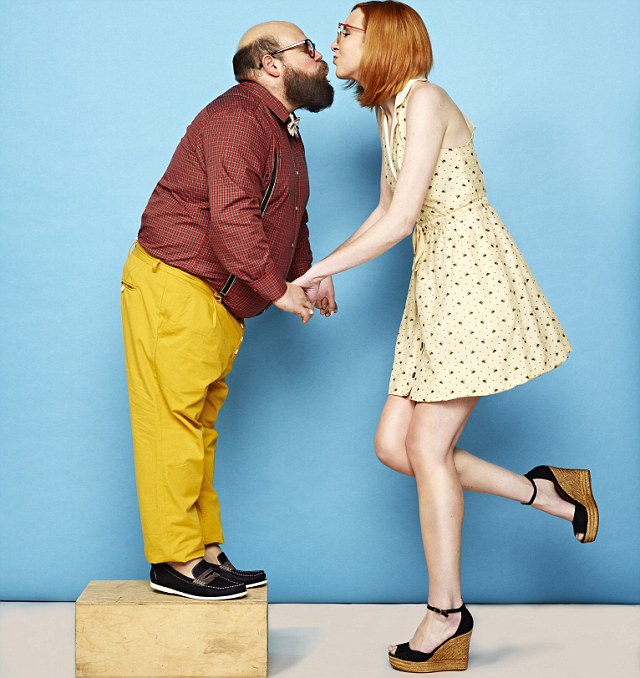 Tall woman and short man kissing --- Image by © Tim Tadder/Corbis